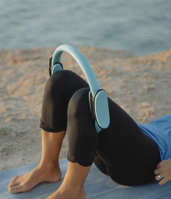 Person doing a dynamic yoga stretch on a mat in nature.